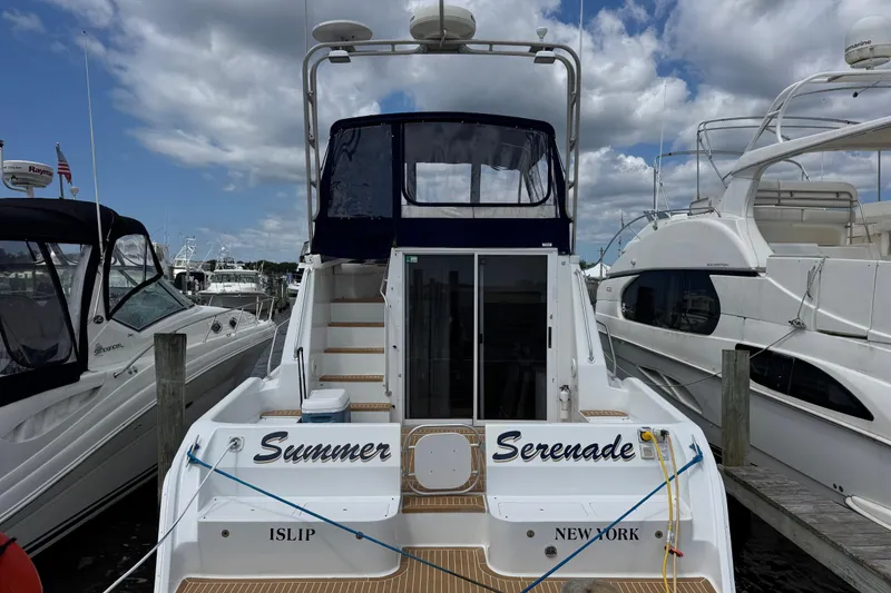 Slide: The Image of 1997 Mainship 40 Sedan Bridge docked, rear view, with "Summer Serenade" name, Islip, New York. - 2