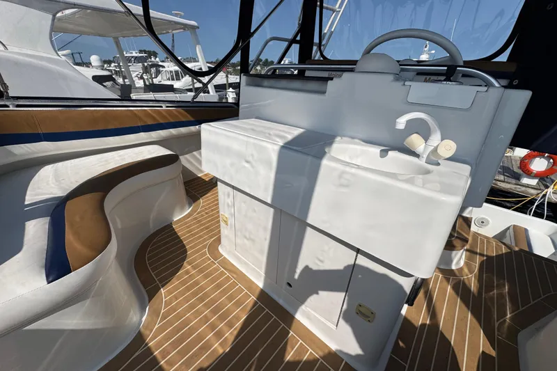 Slide: The Image of 1997 Mainship 40 Sedan Bridge interior with helm, seating, and wood-patterned flooring. - 20