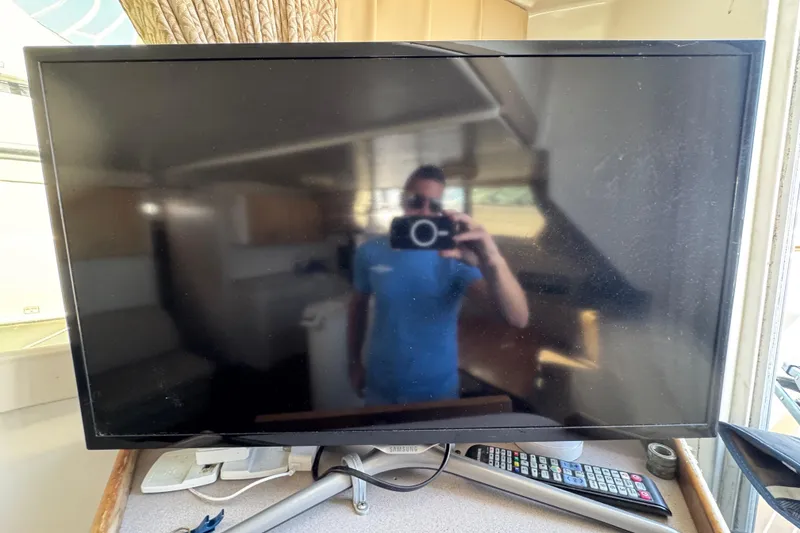 Slide: The Image of Reflection on TV screen inside 1997 Mainship 40 Sedan Bridge boat interior. - 26