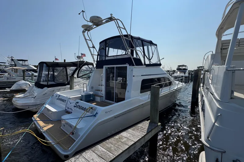 Slide: The Image of 1997 Mainship 40 Sedan Bridge yacht docked at marina, sunny day, calm waters. - 3