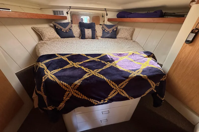 Slide: The Image of Cozy bedroom in 1997 Mainship 40 Sedan Bridge with decorative pillows and nautical-themed blanket. - 30