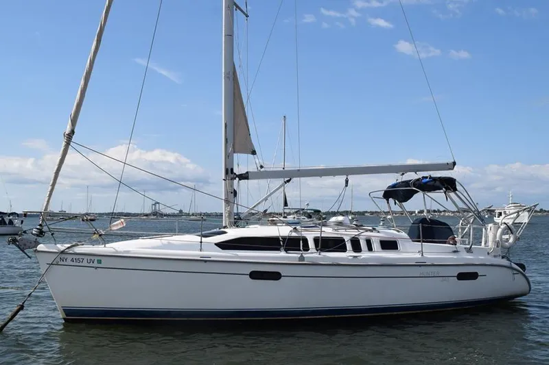 The Image of 2001 Hunter 340 sailboat anchored in a serene harbor under a clear blue sky. - 0