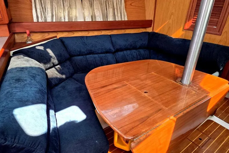 Slide: The Image of Interior of a 2001 Hunter 340 sailboat with a cozy seating area and wooden table. - 24