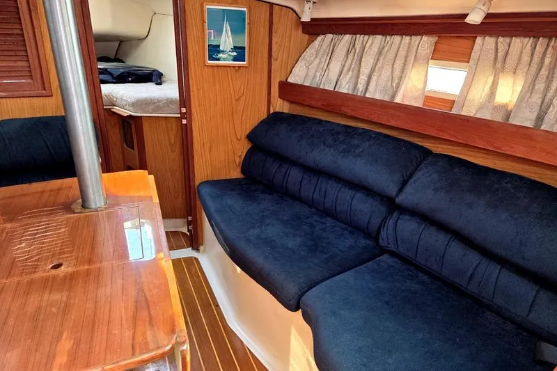 Slide: The Image of Interior of 2001 Hunter 340 sailboat with blue seating and wooden accents. - 25