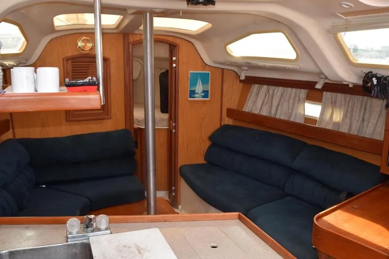 Slide: The Image of Interior of a 2001 Hunter 340 sailboat with cozy seating and wooden finishes. - 26