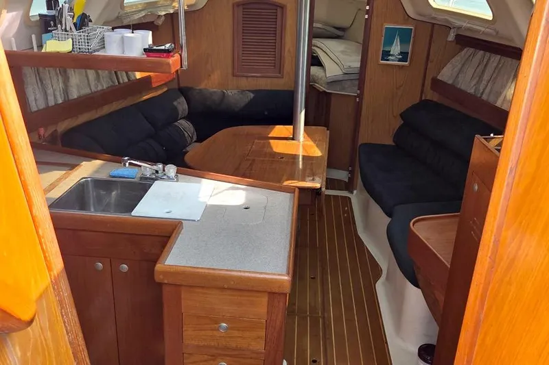 Slide: The Image of Interior of a 2001 Hunter 340 sailboat with wood finish and cozy seating area. - 28