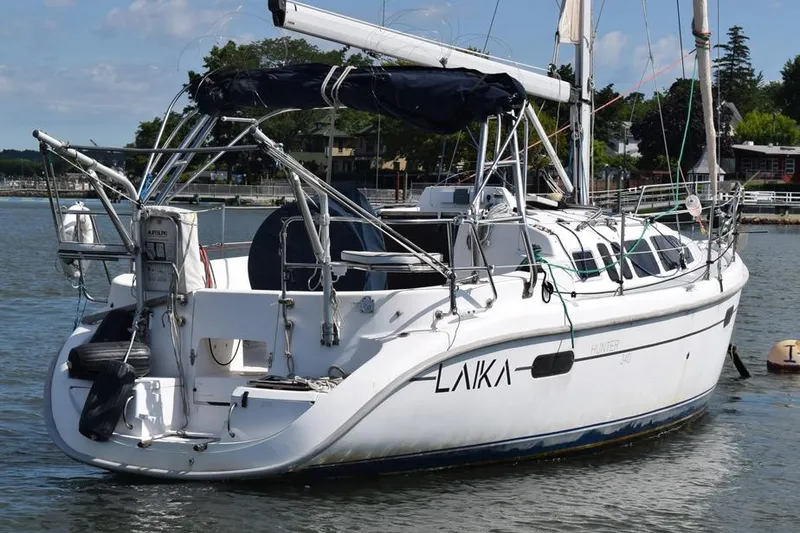 Slide: The Image of 2001 Hunter 340 sailboat docked in a serene marina setting. - 3