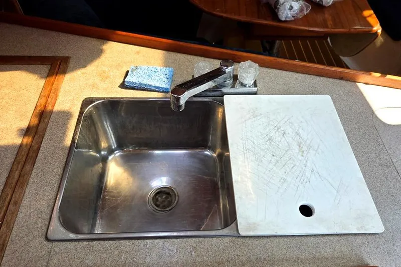 Slide: The Image of Stainless steel sink with faucet and cutting board on a 2001 Hunter 340 yacht. - 32