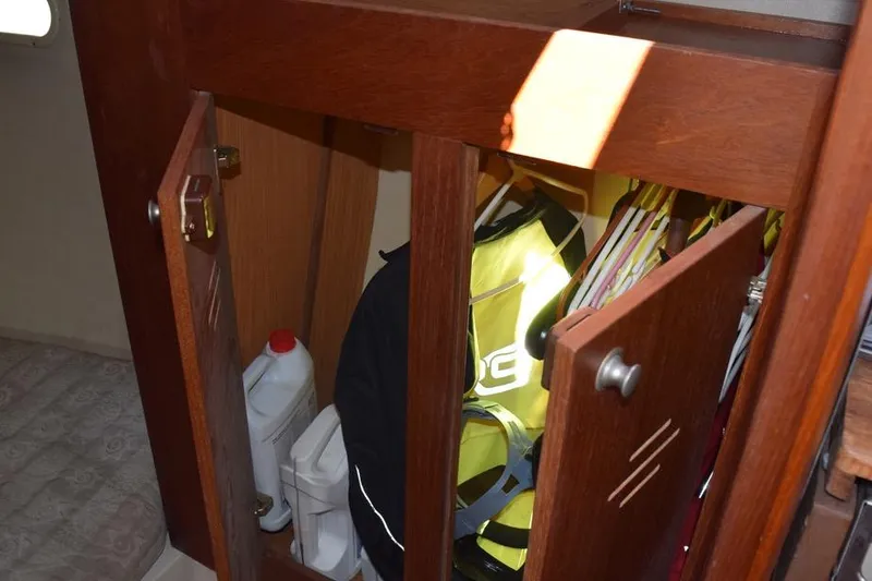 Slide: The Image of Wooden cabinet on 2001 Hunter 340 sailboat, storing life jackets and cleaning supplies. - 36