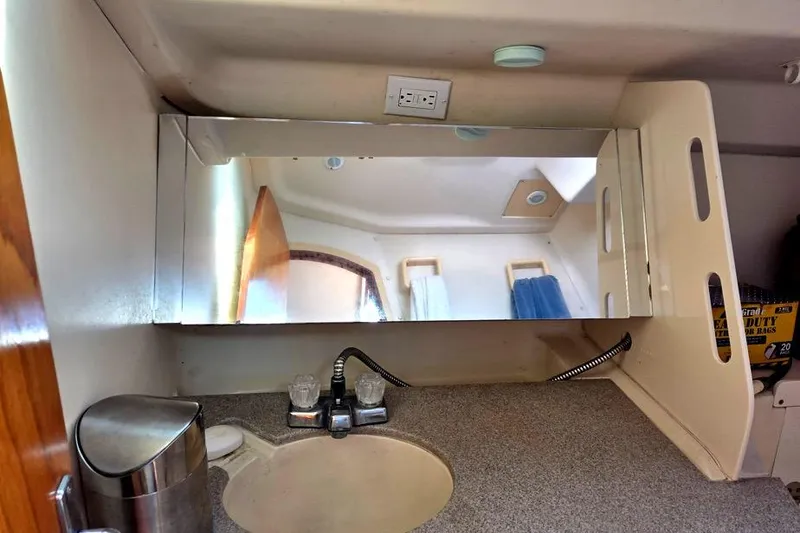 Slide: The Image of Compact bathroom vanity in a 2001 Hunter 340 sailboat, featuring a mirror and sink. - 44