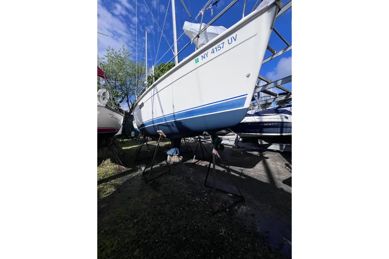 Slide: The Image of 2001 Hunter 340 sailboat on stands, under clear blue sky, in a boatyard. - 50