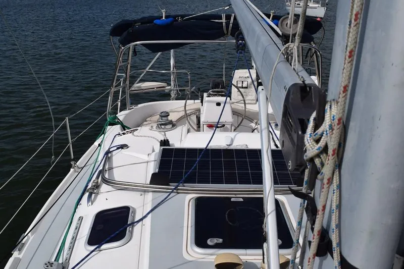Slide: The Image of 2001 Hunter 340 sailboat deck with solar panels and rigging on calm water. - 6