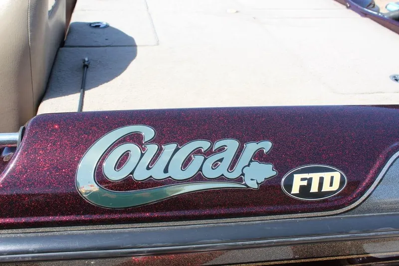 Slide: The Image of 2007 Bass Cat Cougar FTD boat logo on maroon surface. - 16