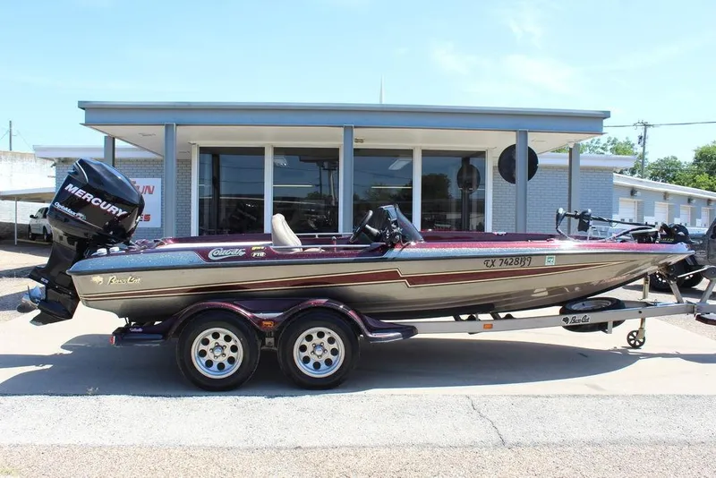 Slide: The Image of 2007 Bass Cat Cougar boat with Mercury engine on trailer, parked outside a building. - 5