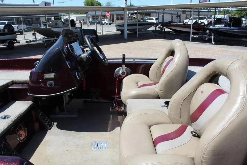 Slide: The Image of 2007 Bass Cat Cougar boat interior with beige and maroon seats, steering console visible. - 9