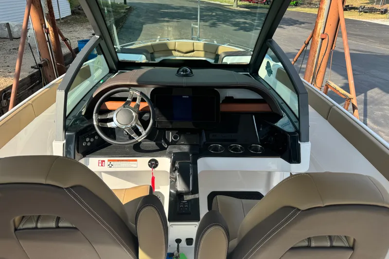 Slide: The Image of Interior view of 2026 Monterey Elite 27 SD boat, featuring modern dashboard and steering wheel. - 12