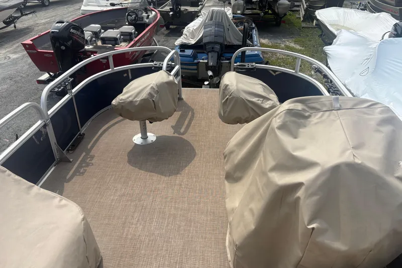 Slide: The Image of 2022 Sun Tracker Bass Buggy 16 XL pontoon boat with covered seats, docked outdoors. - 11