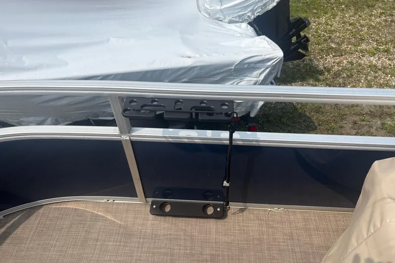 Slide: The Image of 2022 Sun Tracker Bass Buggy 16 XL pontoon boat with covered motor, docked on grass. - 12