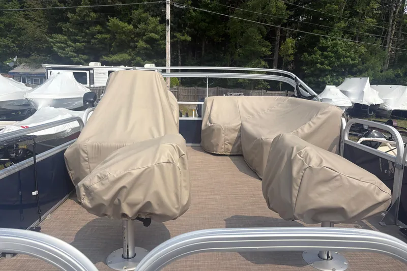 Slide: The Image of 2022 Sun Tracker Bass Buggy 16 XL pontoon boat with covered seats, surrounded by trees. - 3