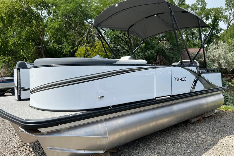 Slide: The Image of 2026 Tahoe TRITOON 2185 pontoon boat with canopy, parked on gravel. - 1