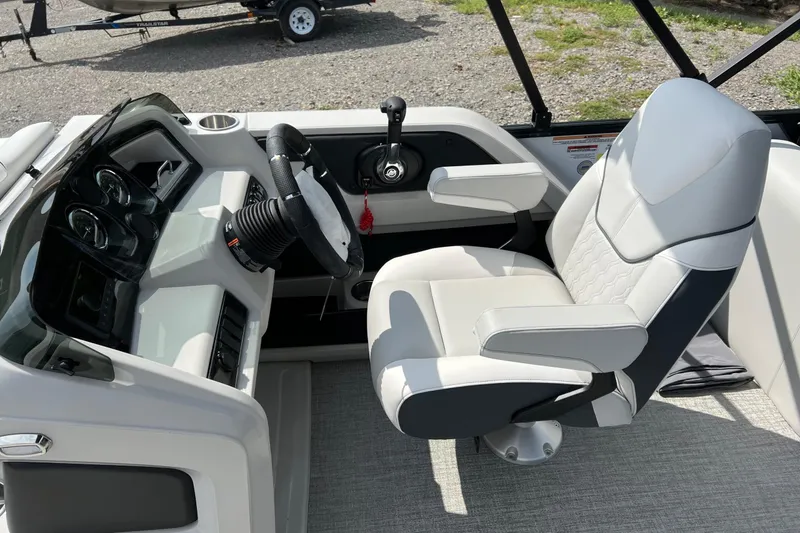 Slide: The Image of 2026 Tahoe TRITOON 2185 boat cockpit with steering wheel and captain's chair. - 16