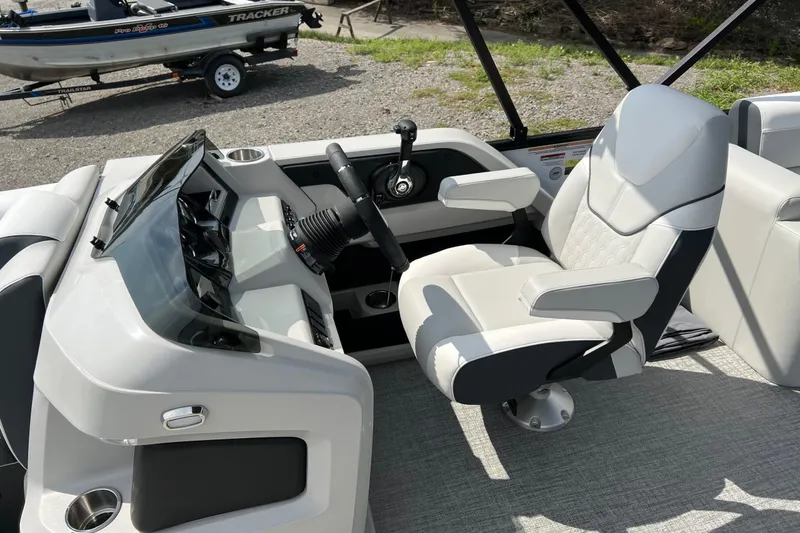 Slide: The Image of 2026 Tahoe TRITOON 2185 boat interior with captain's chair and steering console. - 22