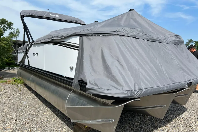 Slide: The Image of 2026 Tahoe TRITOON 2185 pontoon boat with cover on gravel surface. - 26