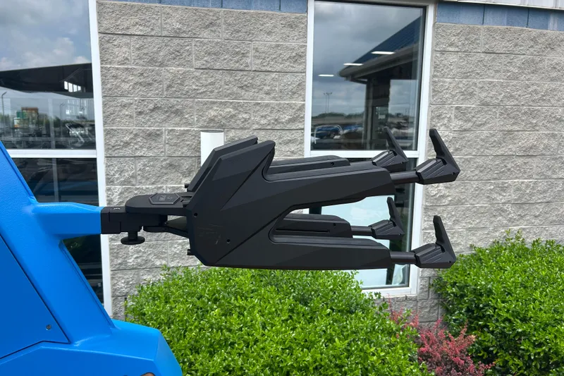 Slide: The Image of 2026 Nautique Super Air Nautique G23 wakeboard rack, mounted on a blue boat, near a building. - 13