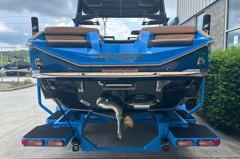 Slide: The Image of 2026 Nautique Super Air Nautique G23 boat, rear view, blue exterior, parked outdoors. - 5