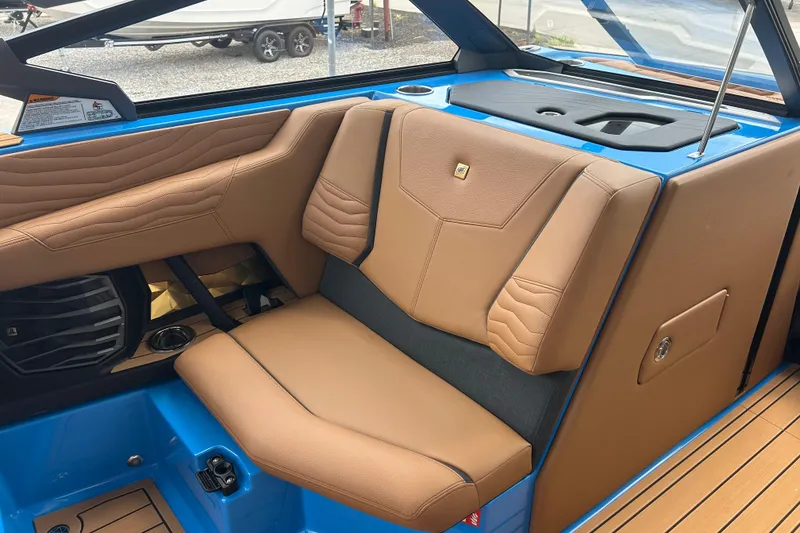 Slide: The Image of 2026 Nautique Super Air Nautique G23 interior with tan leather seating and blue accents. - 7