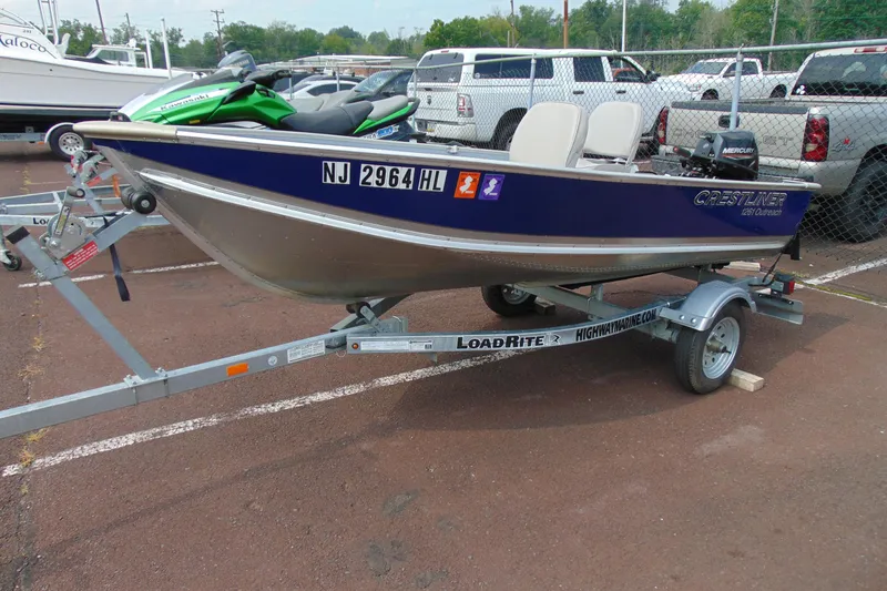 The Image of 2022 Crestliner 1261 Outreach boat on trailer in parking lot. - 1