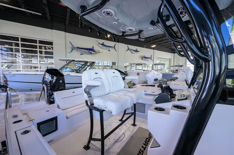 Slide: The Image of 2026 Sportsman Masters 247OE Bay Boat interior with white seating in showroom. - 18