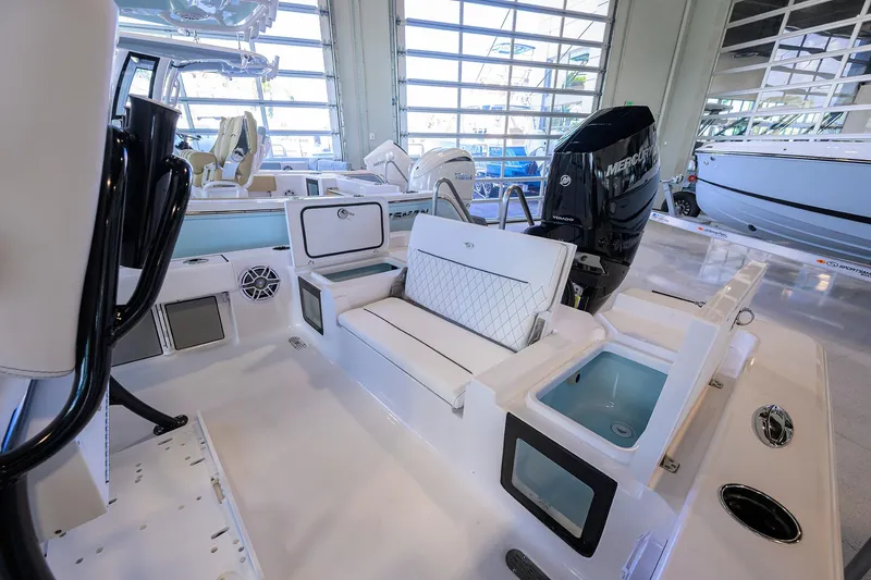 Slide: The Image of 2026 Sportsman Masters 247OE Bay Boat interior with seating and engine in showroom. - 21