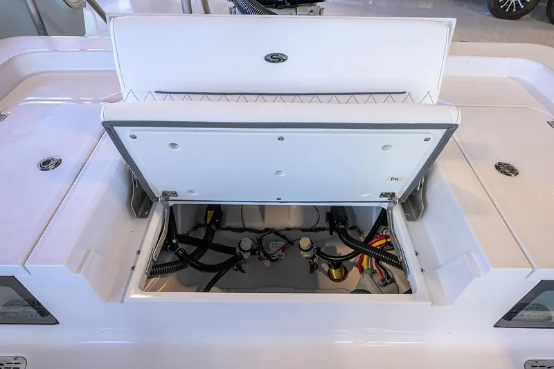 Slide: The Image of 2026 Sportsman Masters 247OE Bay Boat storage compartment with open hatch, showcasing internal wiring. - 25