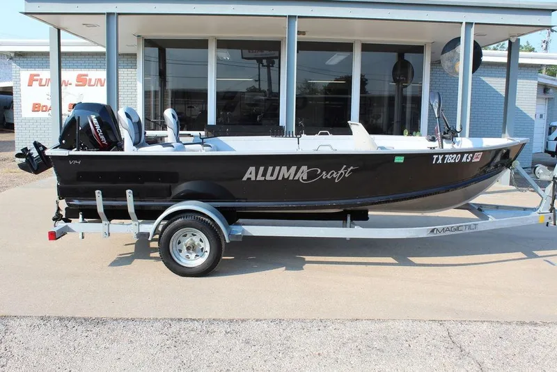 Slide: The Image of 2022 Alumacraft V14 boat on trailer, parked outside a building. - 3