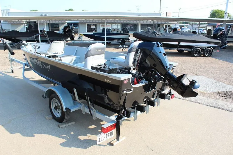 Slide: The Image of 2022 Alumacraft V14 boat on trailer, displayed outdoors at dealership. - 4