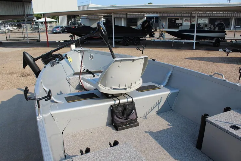 Slide: The Image of 2022 Alumacraft V14 boat interior with seating and equipment, parked in a marina. - 9