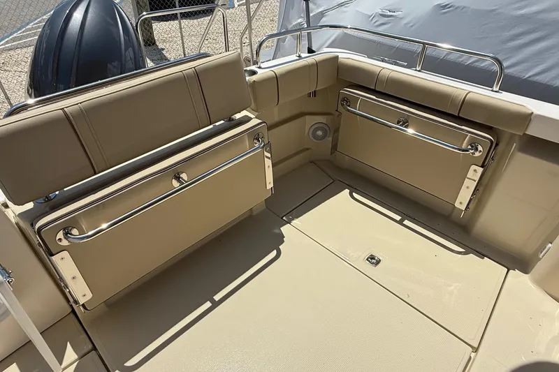 Slide: The Image of 2025 Ranger Tugs R-23 boat interior with foldable seating and beige upholstery. - 11