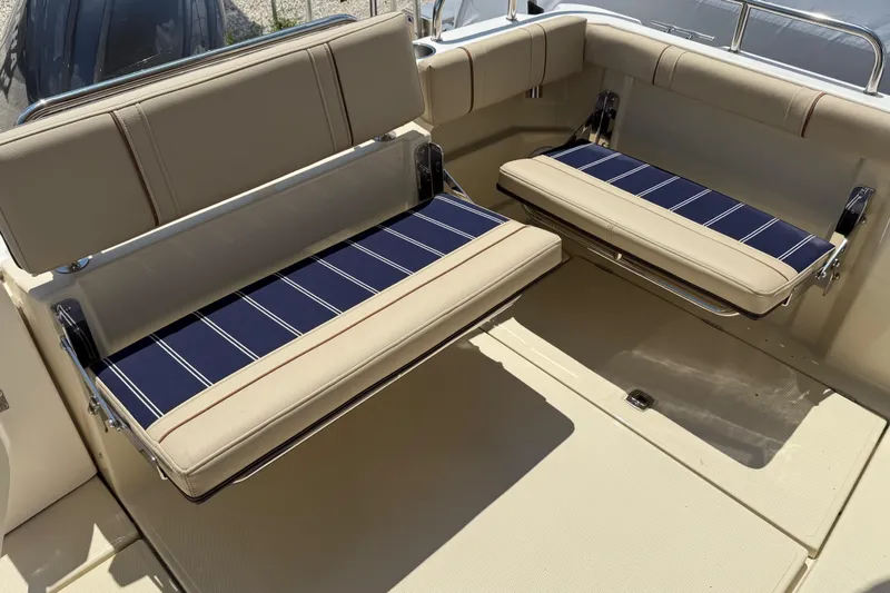 Slide: The Image of 2025 Ranger Tugs R-23 boat seating with blue striped cushions and beige upholstery. - 13