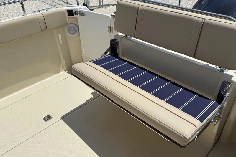 Slide: The Image of 2025 Ranger Tugs R-23 boat interior with foldable seating and striped cushion. - 14