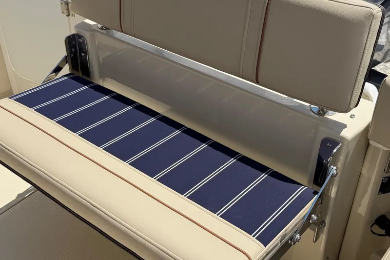 Slide: The Image of 2025 Ranger Tugs R-23 boat seat with blue striped cushion and beige upholstery. - 16