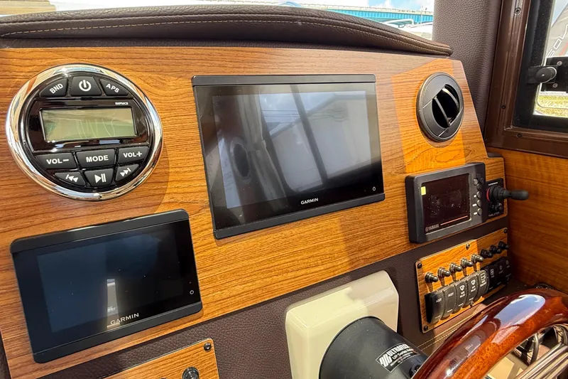 Slide: The Image of 2025 Ranger Tugs R-23 dashboard with Garmin displays and control panel. - 25