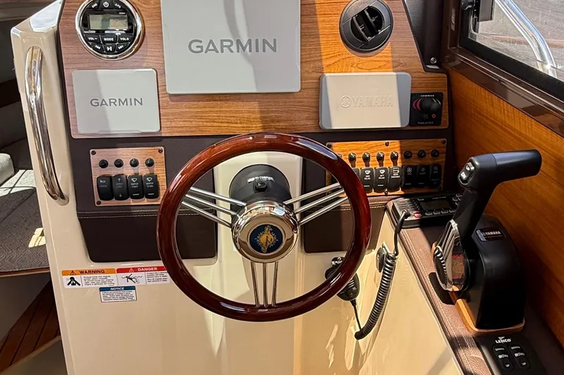 Slide: The Image of 2025 Ranger Tugs R-23 helm with Garmin navigation, Yamaha controls, and wood accents. - 26