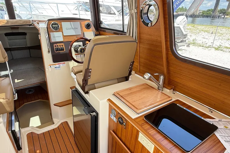 Slide: The Image of Interior of 2025 Ranger Tugs R-23 boat with helm, sink, and seating area. - 28