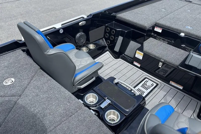 Slide: The Image of 2026 Bass Cat Puma STS interior with gray and blue seating, cup holders, and storage compartments. - 10