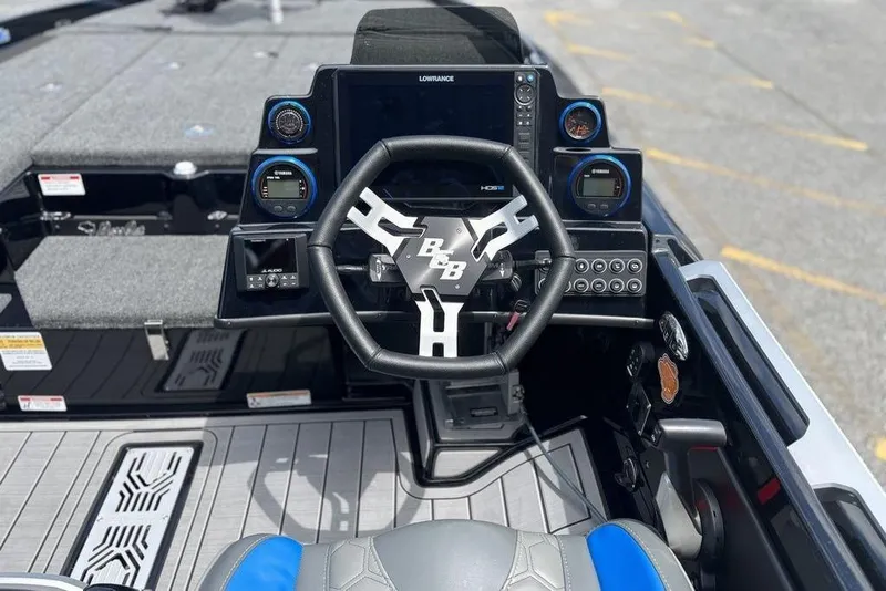 Slide: The Image of 2026 Bass Cat Puma STS boat cockpit with steering wheel and electronic controls. - 12