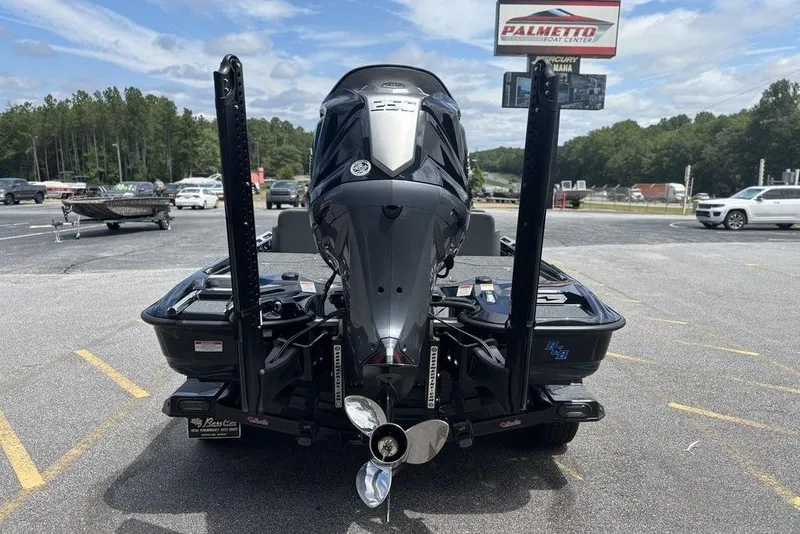 Slide: The Image of 2026 Bass Cat Puma STS boat with powerful outboard motor in parking lot. - 2