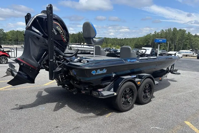 Slide: The Image of 2026 Bass Cat Puma STS boat on trailer, parked outdoors under a partly cloudy sky. - 4