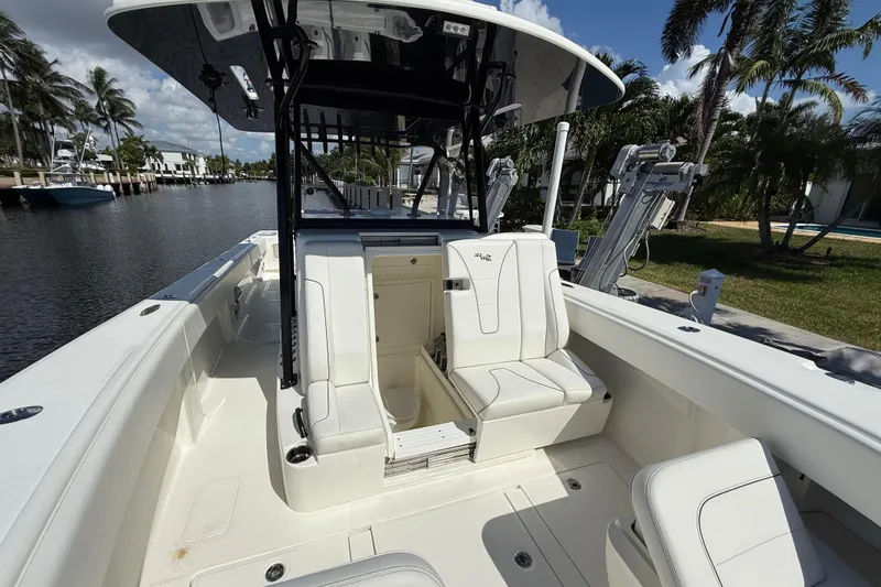 Slide: The Image of 2021 SeaVee 37 boat interior with white seating, docked by a canal. - 10