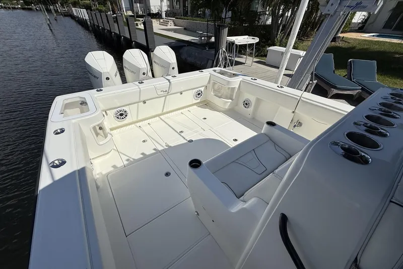 Slide: The Image of 2021 SeaVee 37 boat deck with triple Mercury engines, docked by waterfront. - 15